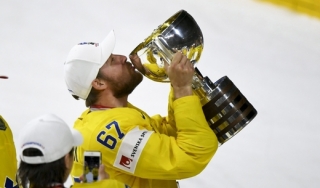 Švéd Linus Omark líbá trofej, kterou Švédský tým získal po desáté ve své historii.