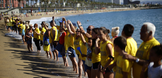 Lidé protestující na barcelonské pláži proti masovému turismu.