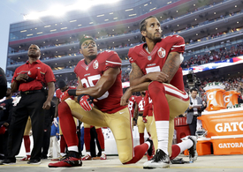 Colin Kaepernick (vpravo), který zahájil protestní akce v NFL.