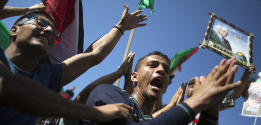 Palestinci, kteří drží plakát palestinského prezidenta Mahmúda Abbáse, oslavují podepsání dohody o usmíření mezi Hamásem a Fatahem v Egyptě.
