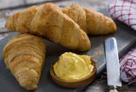 Croissant s máslem, typická francouzská pochoutka.
