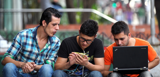 Kubánští mladíci připojení na havanský wi-fi zdroj se snaží podniknout video hovor.