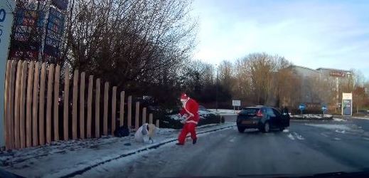 Santa Claus pomáhá ženě, která uklouzla na zledovatělém chodníku.