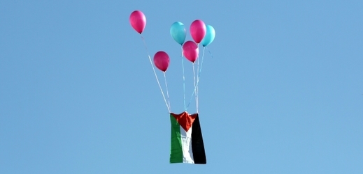 Palestinská vlajka letí do vzduchu během protestů proti Trumpově výrokům. 