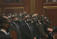 Ochranka kosovské sněmovny s plynovými maskami. 