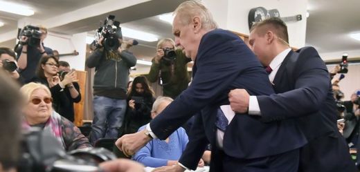Prezidenta Miloše Zemana chrání člen ochranky, poté co se před ním ve volební místnosti vysvlékla žena a vrhla se směrem k němu. Zeman přišel 12. ledna 2018 na pražských Lužinách odevzdat hlas v prvním kole prezidentských voleb.