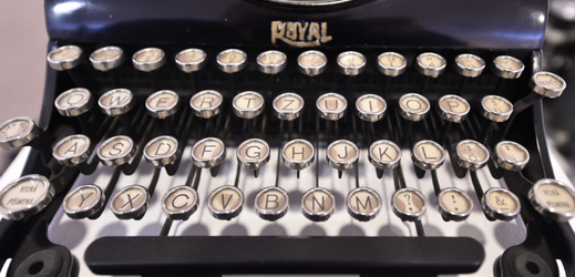 Detail psacího stroje Royal s klapkami vykládanými perletí.