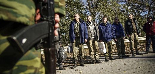 Ukrajinští zajatci, hlídaní ruským vojákem.