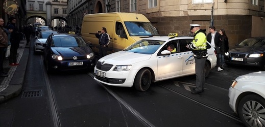 Stovky taxikářů protestujících proti alternativním službám typu Uber odjely 12. února 2018 odpoledne z pražského Strahova. Dorazili na nábřeží a začali kroužit mezi Rudolfinem a Národním divadlem. Na snímku policie řeší situaci na Smetanově nábřeží u Karlových lázní.