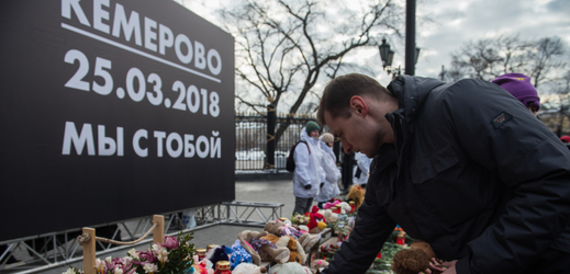 Muž pokládá květiny na památku oběti požáru v Kemerovu. 