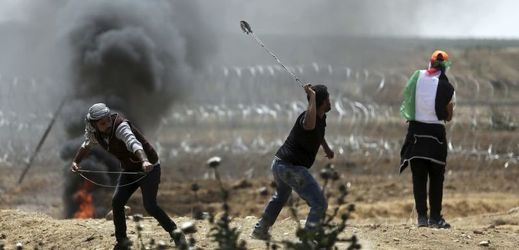 Palestinští protestující házející kameny na izraelské vojáky.