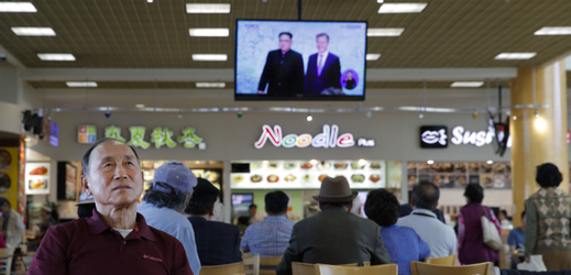Lidé v restauraci sledují korejský summit v televizi. 