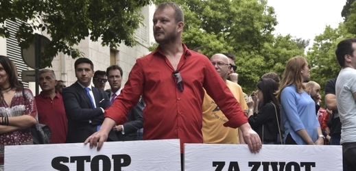 Protest v černohorské Podgorice, muž drží transparenty s nápisy "Stop násilí" a "Za život bez strachu".