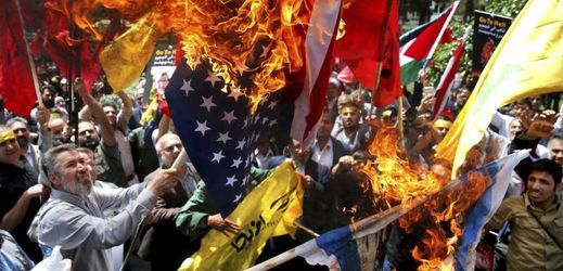 Demonstranti pálící vlajku USA a Izraele při protestech v Gaze.