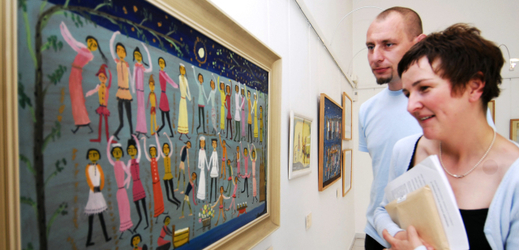 Návštěvníci si prohlížejí obrazy na výstavě naivní malířky Natálie Maslikové-Schmidtové