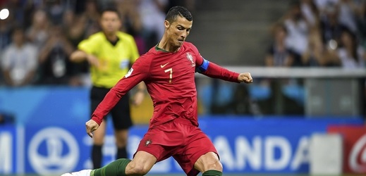 Christiano Ronaldo právě posílá míč přes zeď přesně do sítě.