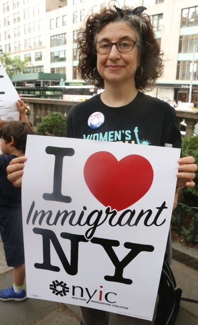 Žena s transparentem "Miluji uprchlíky v NY". (FOTO: ČTK/ZUMA/Nancy Kaszerman).