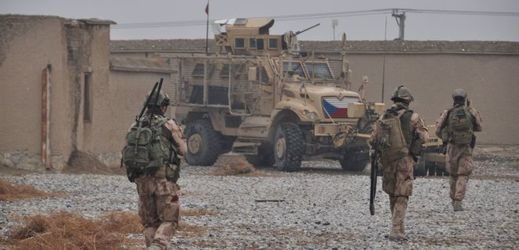 Čeští vojáci na základně Bagrám v Afghánistánu, v pozadí je bojové vozidlo MRAP.
