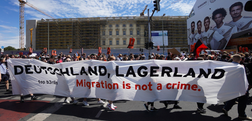 Demonstranti v Berlíně s transparentem: "Migrace není zločin".
