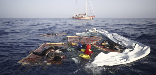 Záchranáři vyzvedávají těla z trosek lodě.