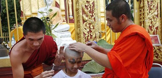 Holení hlavy během buddhistické slavnostní ceremonie.
