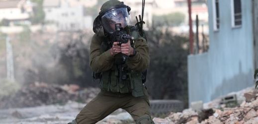 Izraelský voják míří na protestující Palestince.
