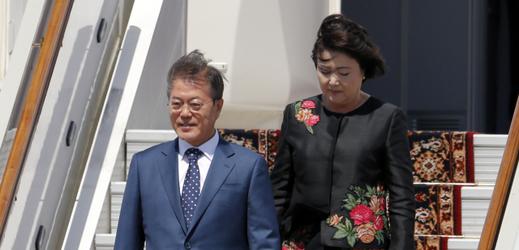 Mun Če-in vystupuje z letadla se svou manželkou Kim Čung-suk. 
