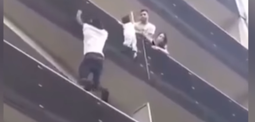 Statečný Malijec zachraňuje dítě, které visí z balkonu.