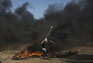Palestinec útočící kamenem.