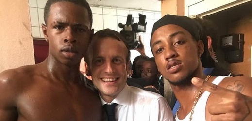 Francouzský prezident Emmanuel Macron se dvěma mladíky.