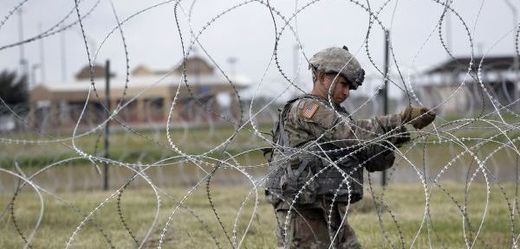 Americký voják natahuje ostnatý drát.