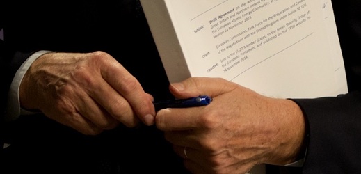 Evropský vyjednavač Michel Barnier drží v ruce část dokumentu.