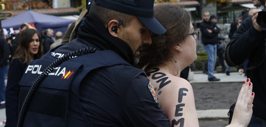 Policista zadržuje členku hnutí Femen na manifestaci v Madridu.
