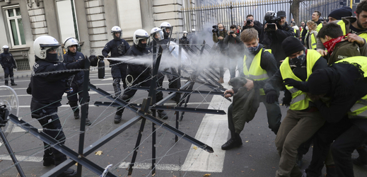 Policie stříká na demonstranty slzný plyn.