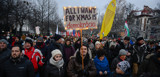 Demonstrant s cedulí s nápisem "Vše, co chci k Vánocům, je demokracie". 