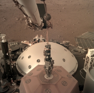 Sonda InSight umisťuje na Marsu svůj první přístroj - seismometr SEIS.