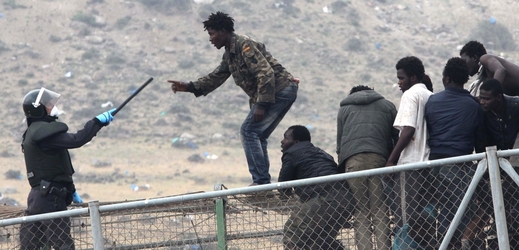 Migranti se snaží dostat přes plot oddělující Maroko od španělské enklávy Melilla.