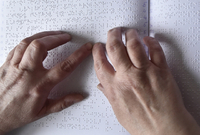 Čtení Braillova bodového písma.