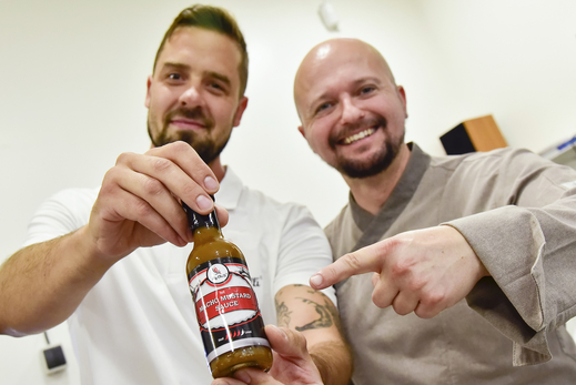 Richard Belžík a Jan Jašek (vpravo) z firmy My-Chilli v Blučině na Brněnsku ukazují na snímku z 12. září 2018 lahvičku silně pálivé omáčky, se kterou získali ocenění na londýnské soutěži Great Taste Awards.