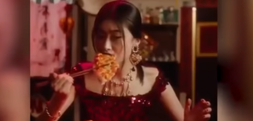 Asiatka konzumuje pizzu hůlkami. 
