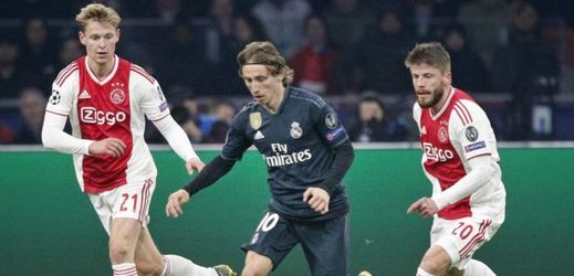 Záložník Realu Madrid Luka Modrič (uprostřed) uniká dvěma protihráčům v zápase Ligy mistrů na hřišti Ajaxu Amsterdam.