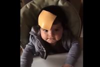 Snímek z jednoho videa, jak rodič hodil po svém dítěti sýr.