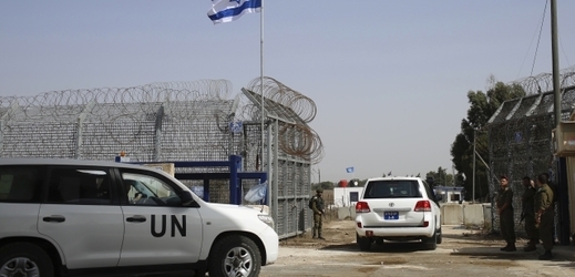 Izraelský voják otevírá pohraniční brány pro vozidlo OSN, které vstupuje na území Sýrie z oblasti Golanských výšin.