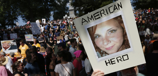 Snímek z demonstrace proti rasismus, žena na transparentu je zavražděná Heather Heyerová.