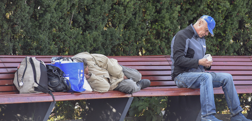 Senior spící na lavičce v Havířově. 