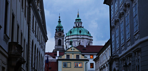 Večerní pohled ze Sněmovní ulice na věže kostela sv. Mikuláše v Praze na Malé Straně.