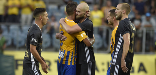 Tomáš Smola (uprostřed v černém) se objímá s bývalým spoluhráčem z Opavy.