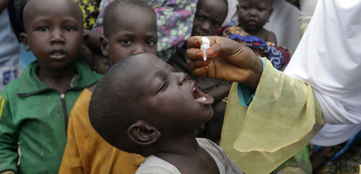 Zdravotník podávající kapky s vakcínou proti dětské obrně.