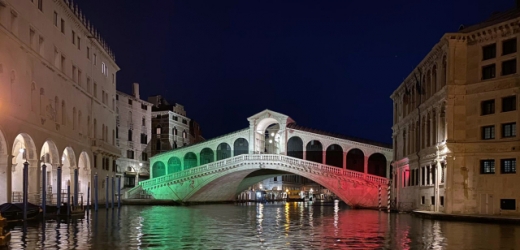 Proslulý benátský most Rialto nasvícený barvami italské vlajky.