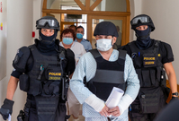 Policisté přivádějí 11. srpna 2020 k jednání u okresního soudu v Karviné muže (uprostřed), kterého policie obvinila z vraždy a obecného ohrožení v souvislosti s požárem panelového domu v Bohumíně. 